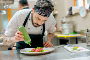 Chef preparing raw meat dish in kitchen Chef preparing raw meat dish in kitchen